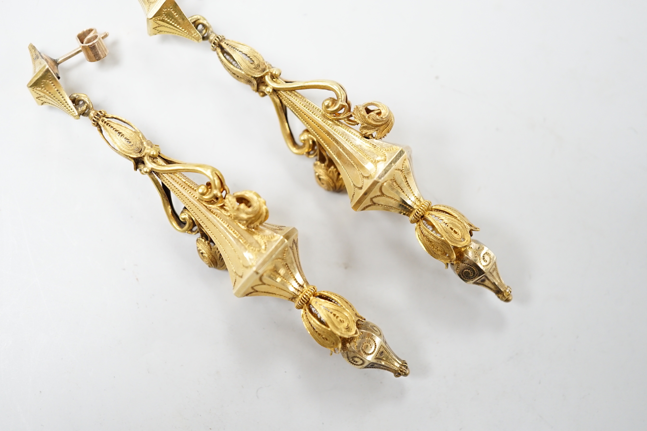 A pair of early 20th century yellow metal drop earrings, with scroll decoration, (later fittings?), 81mm, gross weight 10 grams.